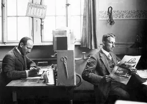 Zwei Männer im Büro, einer arbeitet
