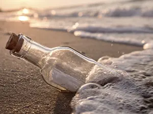 Environmental Pollution Effects Drucke: Message in the bottle washed ashore against the Sun setting down
