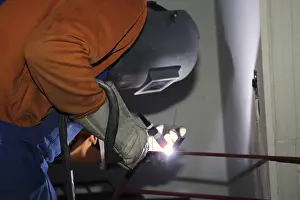 Industrial Equipment Drucke: Metal worker during welding work