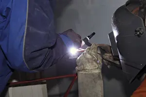 Construction Equipment Use Drucke: Metal worker during welding work