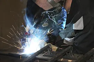 Industrial Equipment Drucke: Metalworker during welding work in his workshop