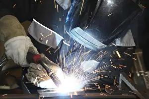 Industrial Equipment Drucke: Metalworker during welding work in his workshop