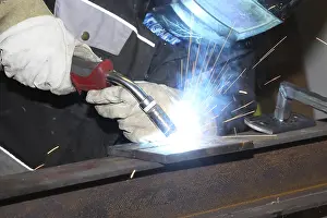 Industrial Equipment Drucke: Metalworker during welding work in his workshop