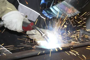Manual Labor Drucke: Metalworker during welding work in his workshop