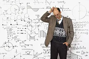 Mathematics Teacher Drucke: Middle aged caucasian mathematician explaining mathematical equations on a white wall