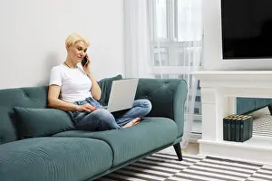 Digital Communication Technology Drucke: Middle-aged woman solves everyday problems remotely using laptop and smartphone