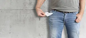 Financial Struggle Drucke: midsection of man turning his empty pockets inside out