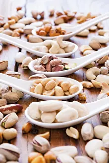Deserted Table Scene Drucke: Mix of nuts over a rustic table in backlit