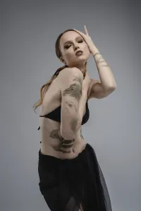 Fashionable Facial Expression Drucke: A model showcases her artistic tattoos while posing elegantly in a professional studio setting