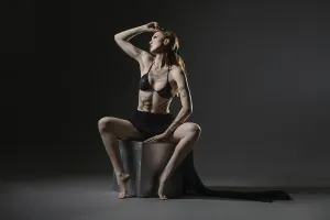 Self Confident Facial Expression Drucke: A model showcases her striking pose in a dimly lit studio