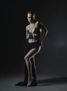 Confident Model Pose Drucke: A model stands confidently in a dark studio