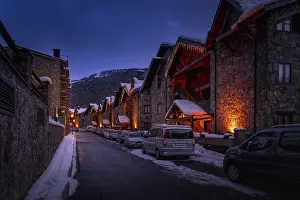 Drucke von Moderne Steinhäuser und Wohnungen, die von Straßenlaternen beleuchtet werden, im Dorf El Tarter bei Sonnenuntergang oder Abenddämmerung in den Pyrenäenbergen, Grandvalira, Andorra Andorra Drucke: Moderne Steinhäuser