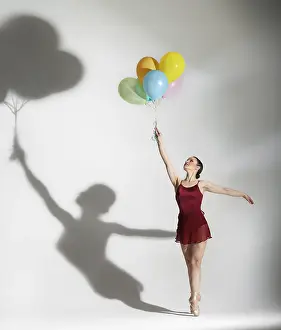 Ballet Dancer Pose Drucke: Modern style ballet dancer posing with ballons on studio background
