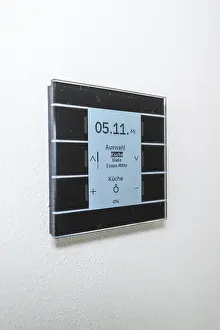 Minimalism In Interior Design Drucke: A modern switch on the wall with a blue display