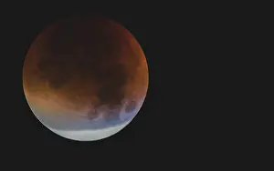 Partial Lunar Eclipse Drucke: A moon with visible orange and blue tones during a partial lunar eclipse