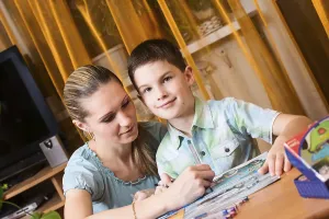 Child Learning At Home Drucke: Mother and boy doing homework together and posing