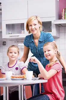 Mother Daughter Bonding Moments Drucke: Mother and two daughters having breakfast in the kitchen