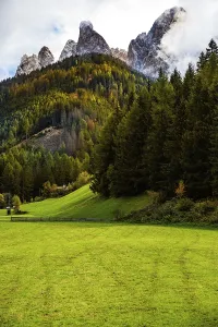 Bilder Datiert 4. Oktober 2024: Berglandschaft mit grünen Feldern und dichten Wäldern.