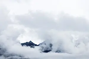 Cloudy Mountain Peak Drucke: Mountain peak rises from clouds