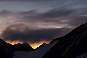 Dramatic Clouds Austria Drucke: Mountain ridge at sunrise with dramatic clouds