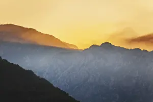Atmospheric Light Of The Setting Sun Drucke: Mountain sunset and colored sky with clouds