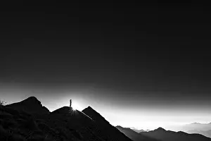 Backlit Mountain Peak Drucke: Mountaineer on summit ridge with backlight