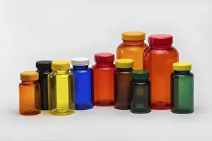 Pharmaceutical Packaging Solutions Drucke: Multi colored transparent plastic pill jars on a white background