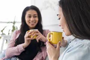 Christmas Season Drucke: Multiethnic girlfriends talking drinking tea