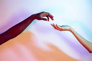 Vibrant Gradient Background Drucke: Two multiethnic hands reaching towards each other