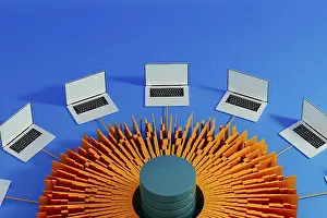 Modern Workspace Drucke: Multiple laptops surround a central data hub