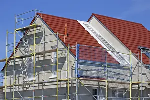 Construction Site Image Drucke: New building with completed basic rendering of the exterior facade New building with completed basic rendering of