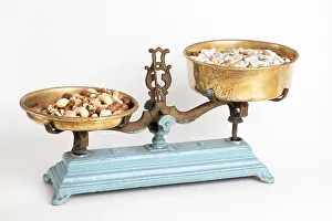 Medical Remedy Concept Drucke: Nuts on one side of an antique scale and medication on the other