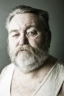 Caucasian Man Photo Drucke: Obese senior with a full beard and in his undershirt