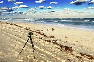 Uninhabited Coastline Images Drucke: Old camera on the sandy beach