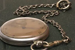 Blurry Green Background Drucke: Very old clock with chain lying on rough green surface