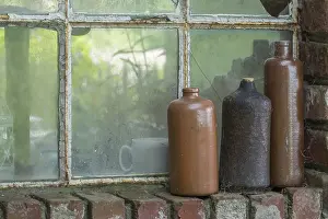 Rustic Country Style Decor Drucke: Three old earthenware bottles in front of a stable window