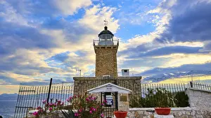 Lighthouse At Sunset Drucke: An old lighthouse overlooked by a dramatic sky at sunset