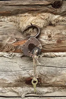 Wooden Wall Background Drucke: Old padlock with key on a background of a timber wall