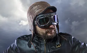 Caucasion Ethnicity Male Portrait Drucke: Old plane pilot on background of storm clouds with expressive face