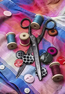 Handicraft Tools Drucke: Old scissors and thread and buttons on textured background fabric