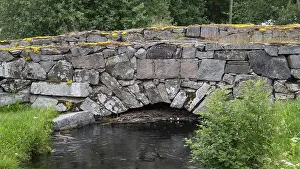 Scandinavian Deserted Landscapes Drucke: Old stone bridge crosses the river Risa