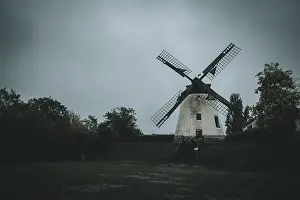 Cloudy Daytime Scene Drucke: An old windmill on a cloudy day