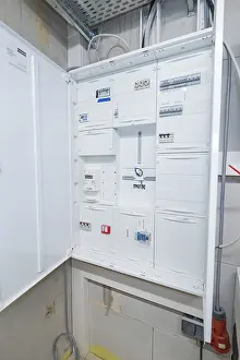 Power Supply Technology Drucke: Open electrical cabinet with various control boxes in a technical room