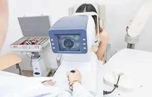 Medical Equipment Drucke: Optometrist using refractometer with patient