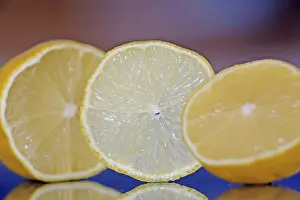 Citrus Fruit Images Drucke: A orange slice is standing between two half oranges