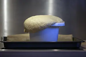 Kitchen Utensil Use Drucke: Overflowing bread dough in a baking tin shows the fermentation process in the kitchen