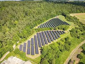German Renewable Energy Drucke: Overview of a solar panel landscape surrounded by lush forests and open fields