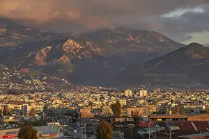 Dramatic European Skies Drucke: Panorama of a city against a mountainous backdrop with dramatic clouds