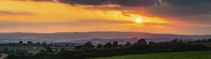 Cloudy Sky With Setting Sun Drucke: Panorama of Sunset over Torquay Fields