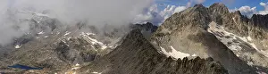 Rugged Mountain Landscape Drucke: A panoramic view of a rugged mountain range partially covered by clouds